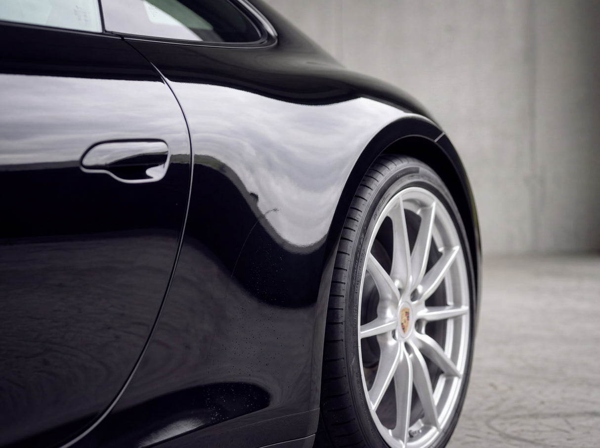 Saubere schwarze Porsche 911 Heckflanke nach der Behandlung mit streifenfreier Silberfelge ohne Flugrost-Punkte