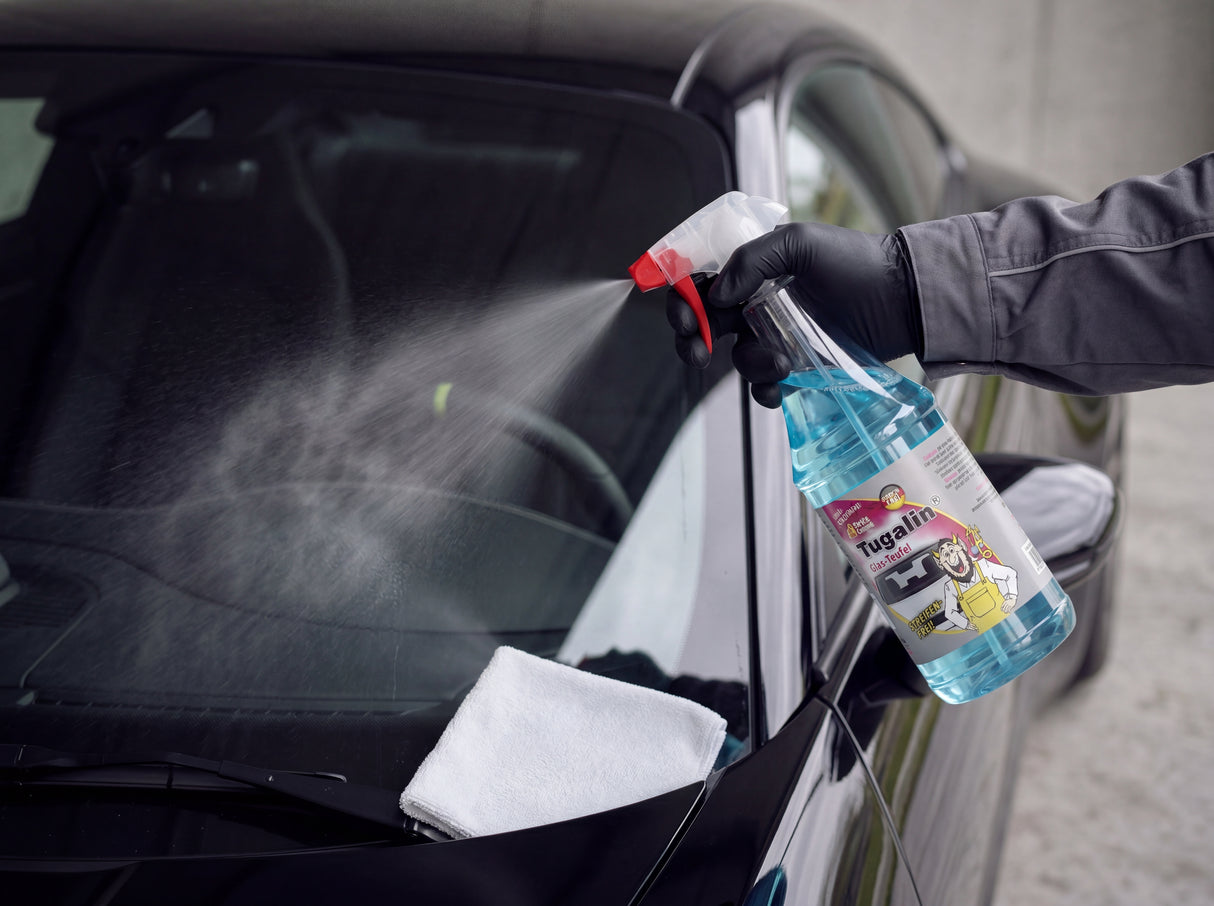 Tugalin Glasreiniger wird mit Nitrilhandschuh und weißem Glastuch auf die Frontscheibe eines Porsche 911 aufgesprüht