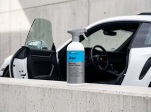 Koch-Chemie ASC 500 ml auf Beton-Mauerkante vor schwarzem Fahrzeuginnenraum