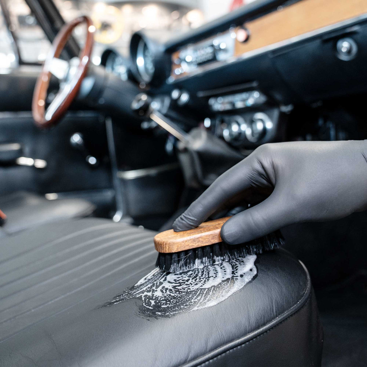Detailing1 COLOURLOCK Oldtimer-Lederpflege — Ledersitz eines Oldtimers mit Bürste und Schaum reinigen